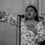 Microphone Techniques - A woman singing into a microphone in front of a microphone