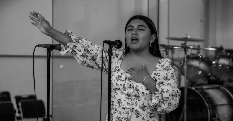 Microphone Techniques - A woman singing into a microphone in front of a microphone