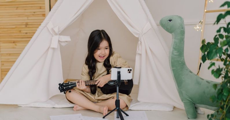 Recording Acoustic Instruments - A Cute Girl Recording a Video while Playing Ukulele