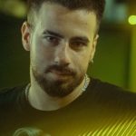 DJ Library - A man with a beard standing in front of a bar