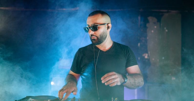 DJ Effects - A Bearded Man Using an Audio Mixer on a Nightclub