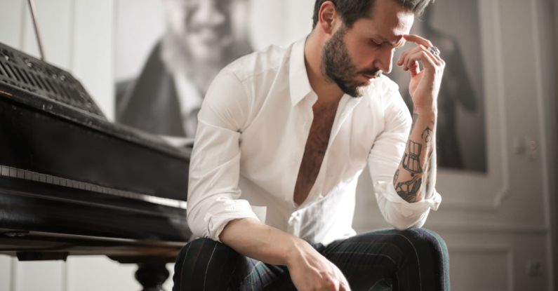 Sound Balancing - Dramatic tattooed male sitting at piano