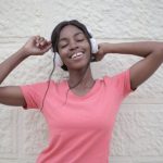 Wireless Audio Quality - Cheerful black woman with earphones dancing