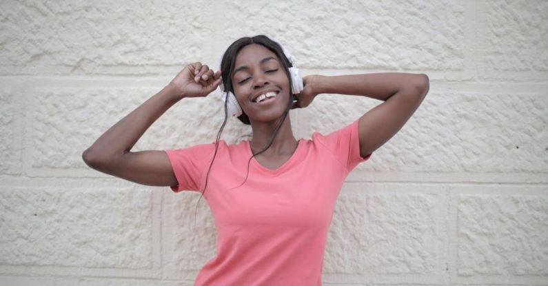 Wireless Audio Quality - Cheerful black woman with earphones dancing
