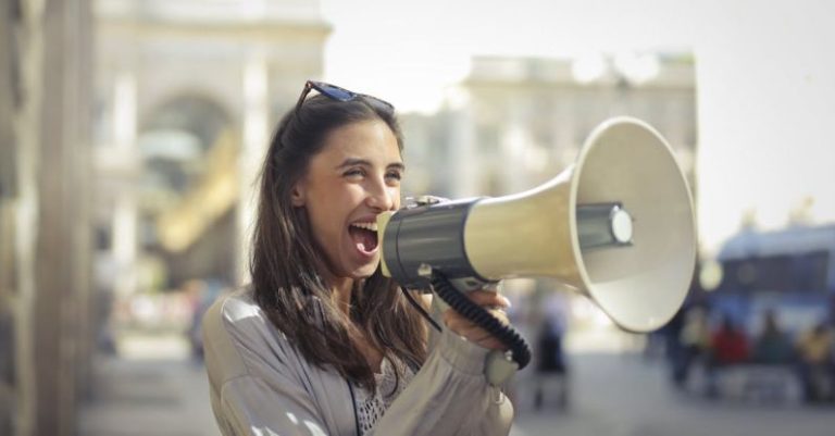 Surround Sound Technology - Cheerful young woman screaming into megaphone