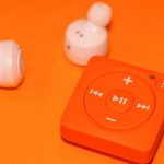 MP3 Compression - White Earphones Beside Orange Music Player