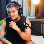 Podcast Editing - A man with purple hair sitting in front of a microphone