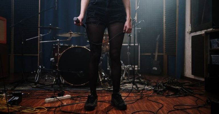 Microphone - Woman in Black Denim Shorts Standing on Brown Wooden Floor