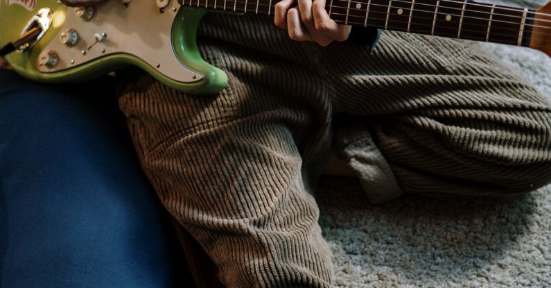 Home Studio - Person Playing Red and White Stratocaster Electric Guitar